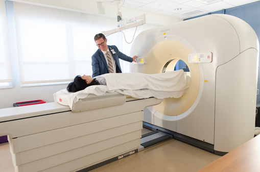 A doctor operating a CT scan with patient on bed