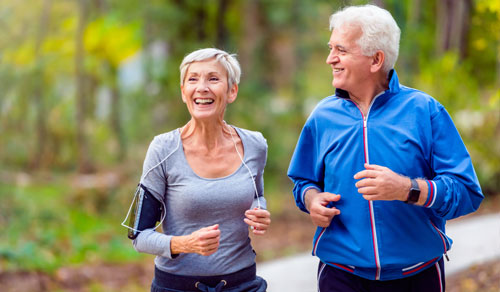 Older couple jogging in the woods