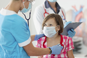 doctor wearing mask listening to child heart beat