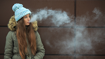 Vaping teenager girl smoking an electronic cigarette