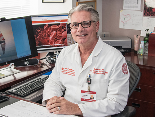 Dr. Dix Poppas sitting at his desk