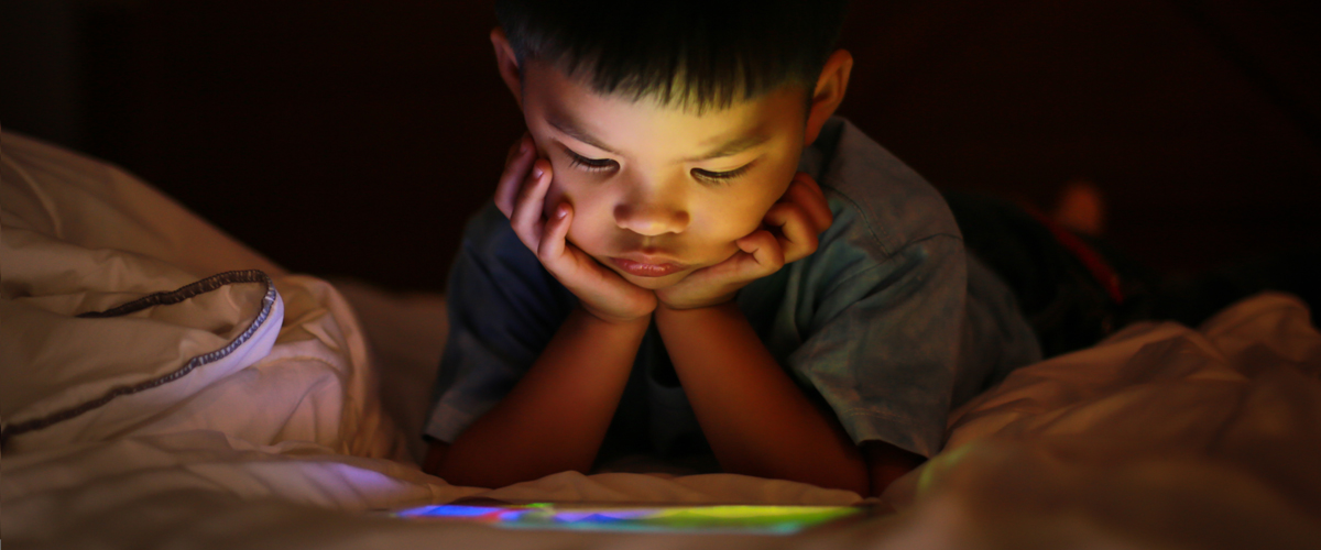 a boy with his hands on his face watching videos on his smartphone