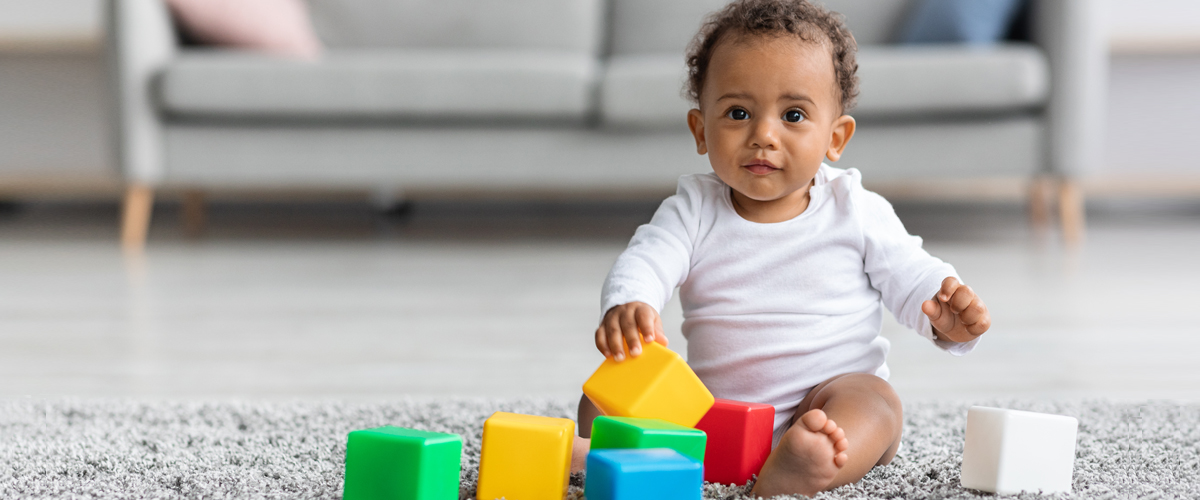 image of baby on floor playing with blocks