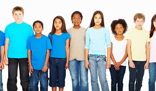 Portrait of serious multi ethnic children standing in a row against white background