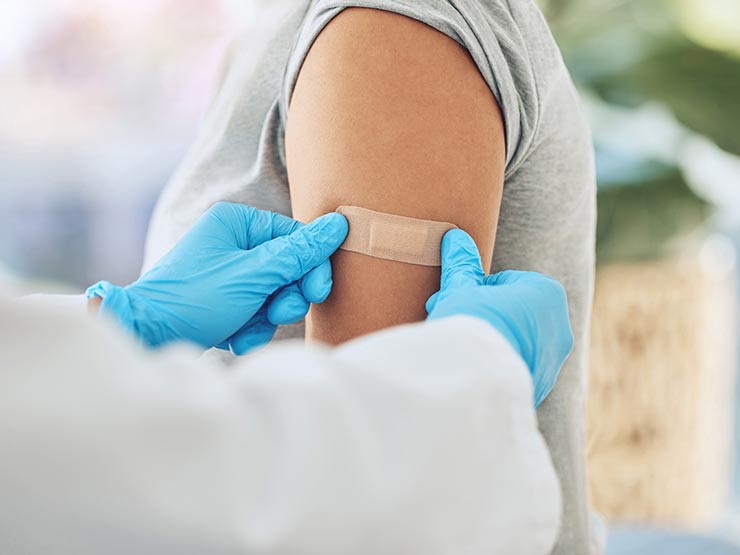 image of doctor putting band-aid on arm of patient