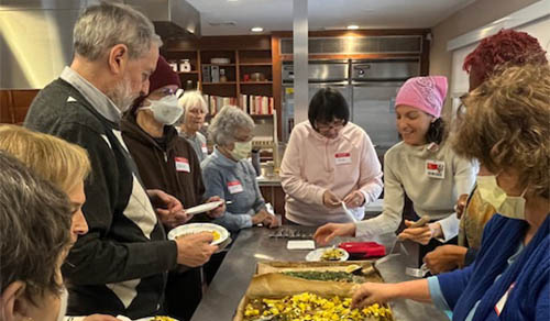 A woman making a salad in the kitchen.