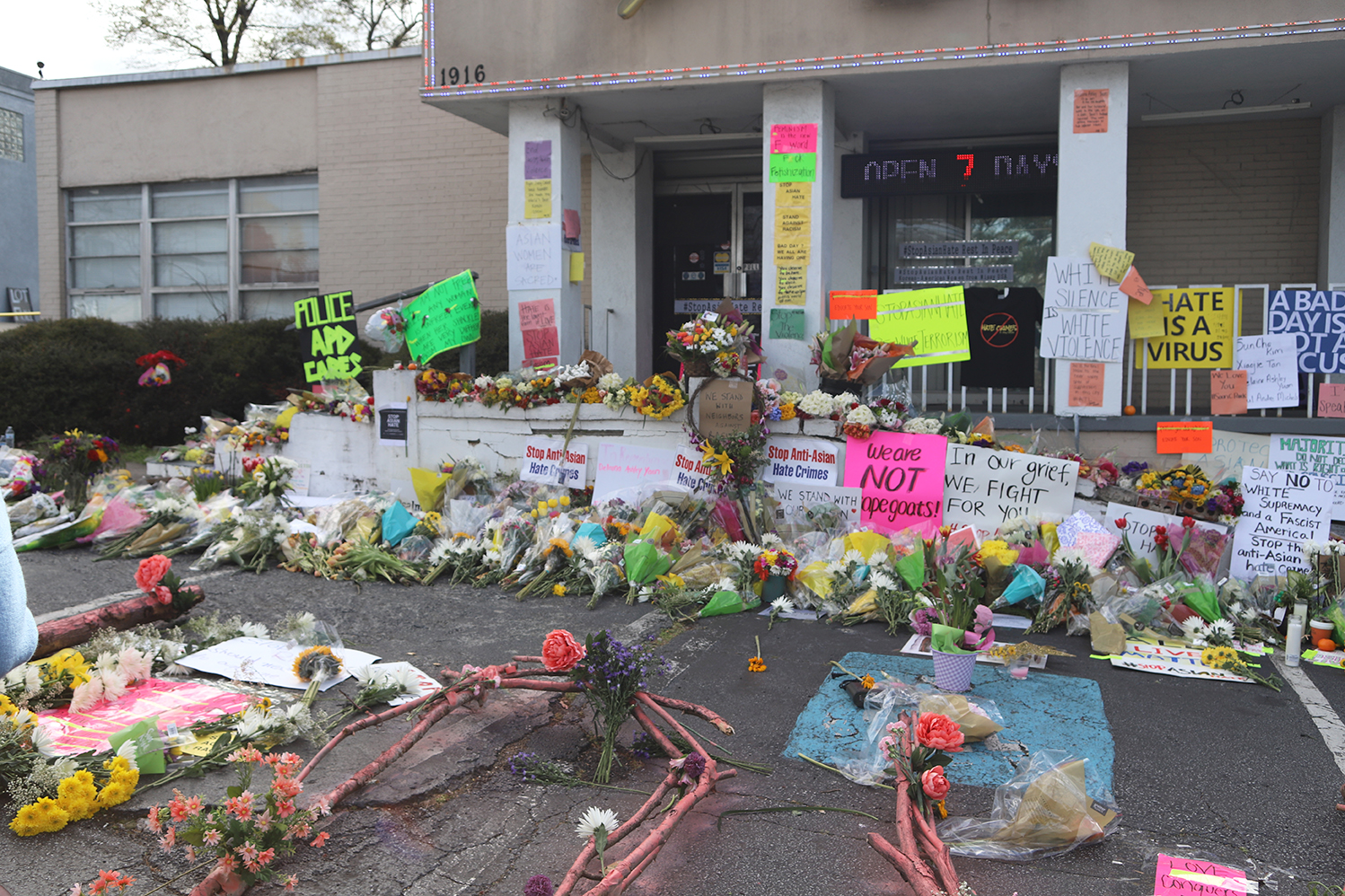 Mourners leave flowers and signs outside Gold Spa, one of the sites of the mass shooting in Atlanta in March. The gunman killed eight people, six of whom were women of Asian descent. Credit: Jerel Cooper/Shutterstock.com