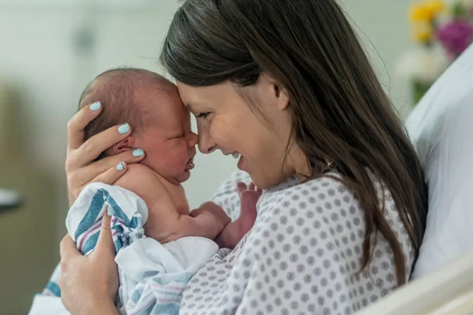 Mother holding her newborn in hospital bed