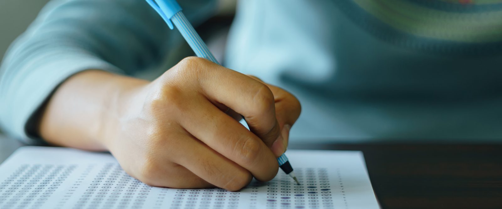 Closeup of a hand taking a test on paper.