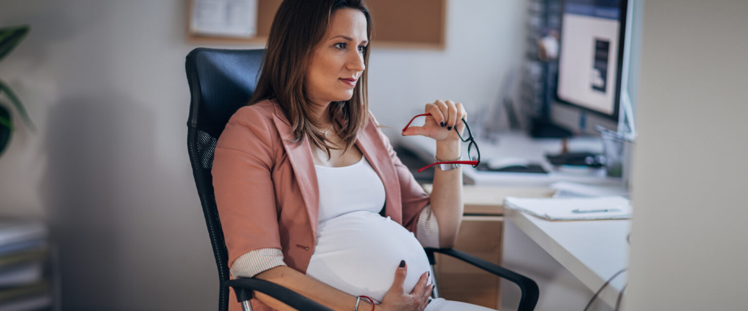a pregnant woman holding her glasses