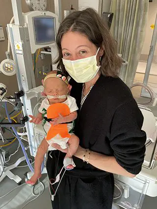 Jessica Saal with baby Lola, who is dressed up as a sushi roll.