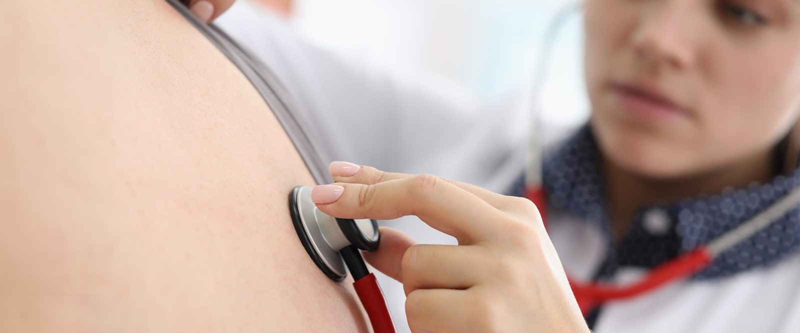 Doctor checking a patient's breathing with a stethoscope