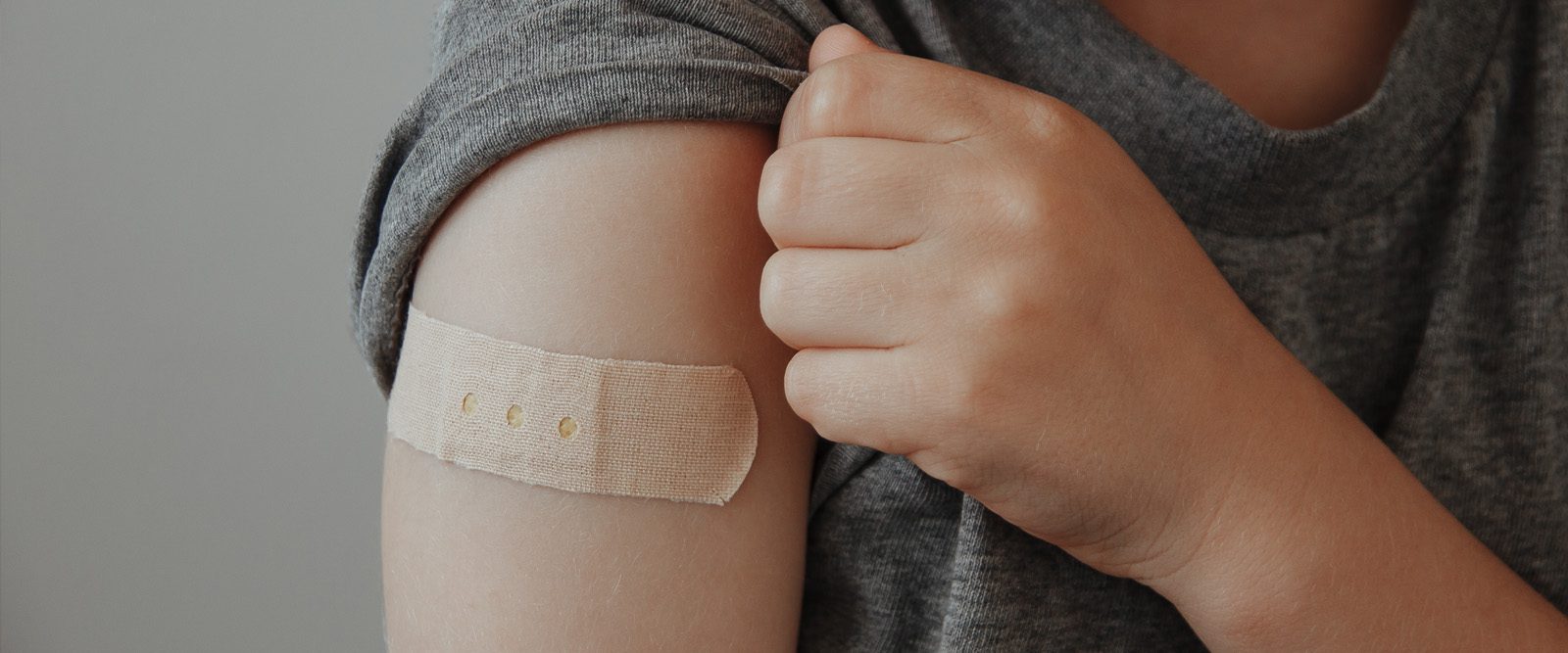 Child's arm with a band aid after vaccination