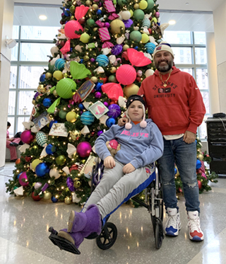 Anthony Donahue and his sister Gianna in front of a Christmas tree at NewYork-Presbyterian Morgan Stanley Children’s Hospital