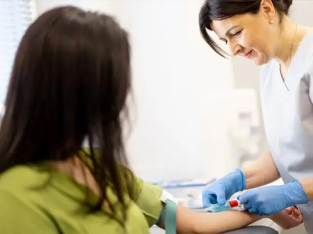 a nurse taking a blood sample from another women