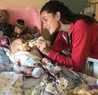 Ruby feeding from a bottle with her mom’s help