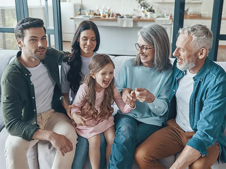 A family sitting on the couch.