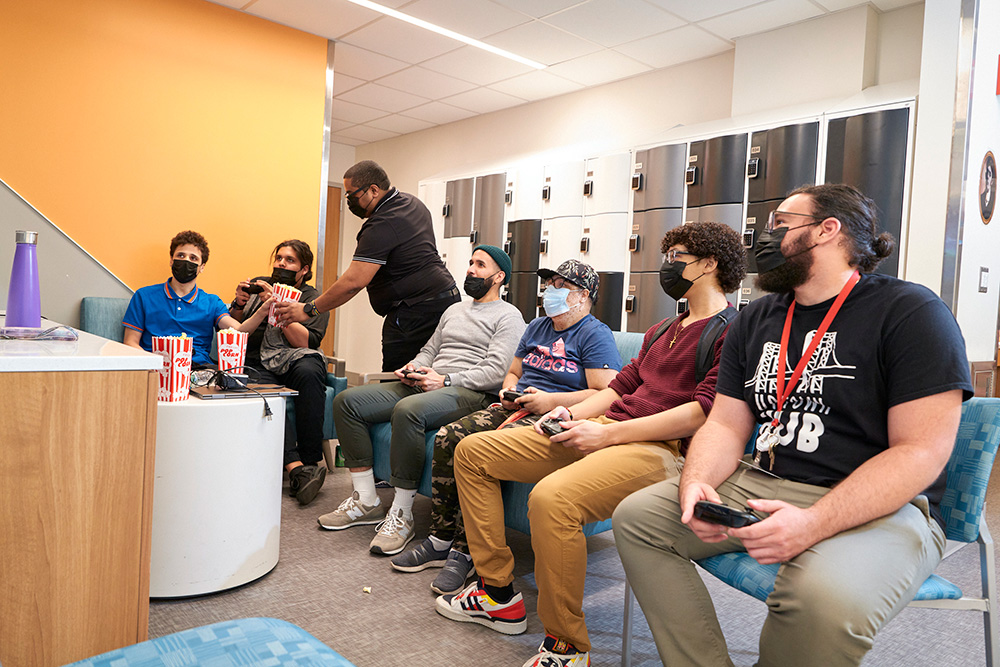 group pic of members playing video games together