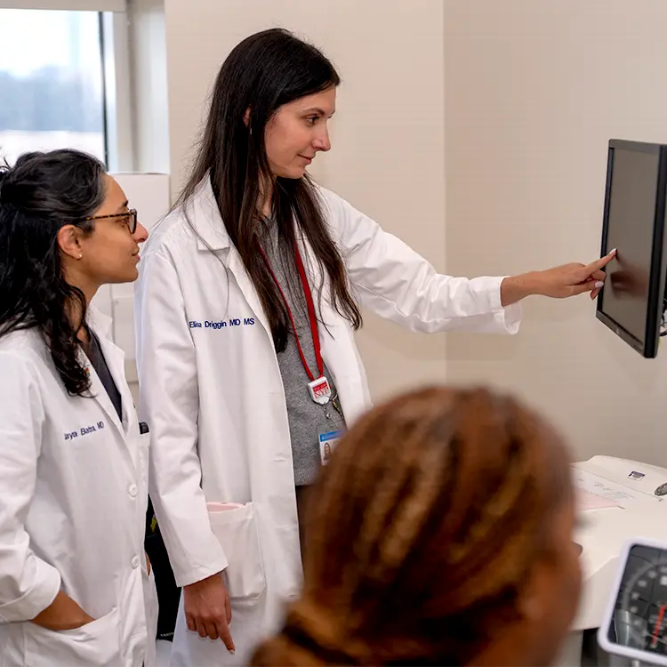 two female physicians looking at a screen