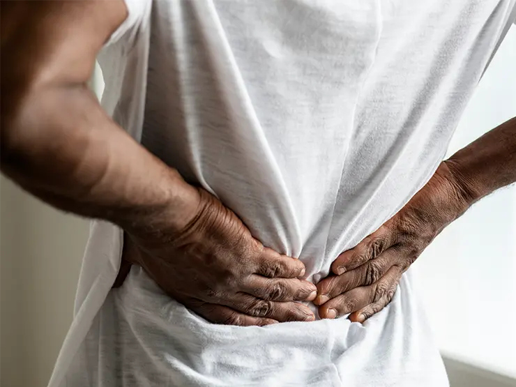 Image of man holding on to his lower back