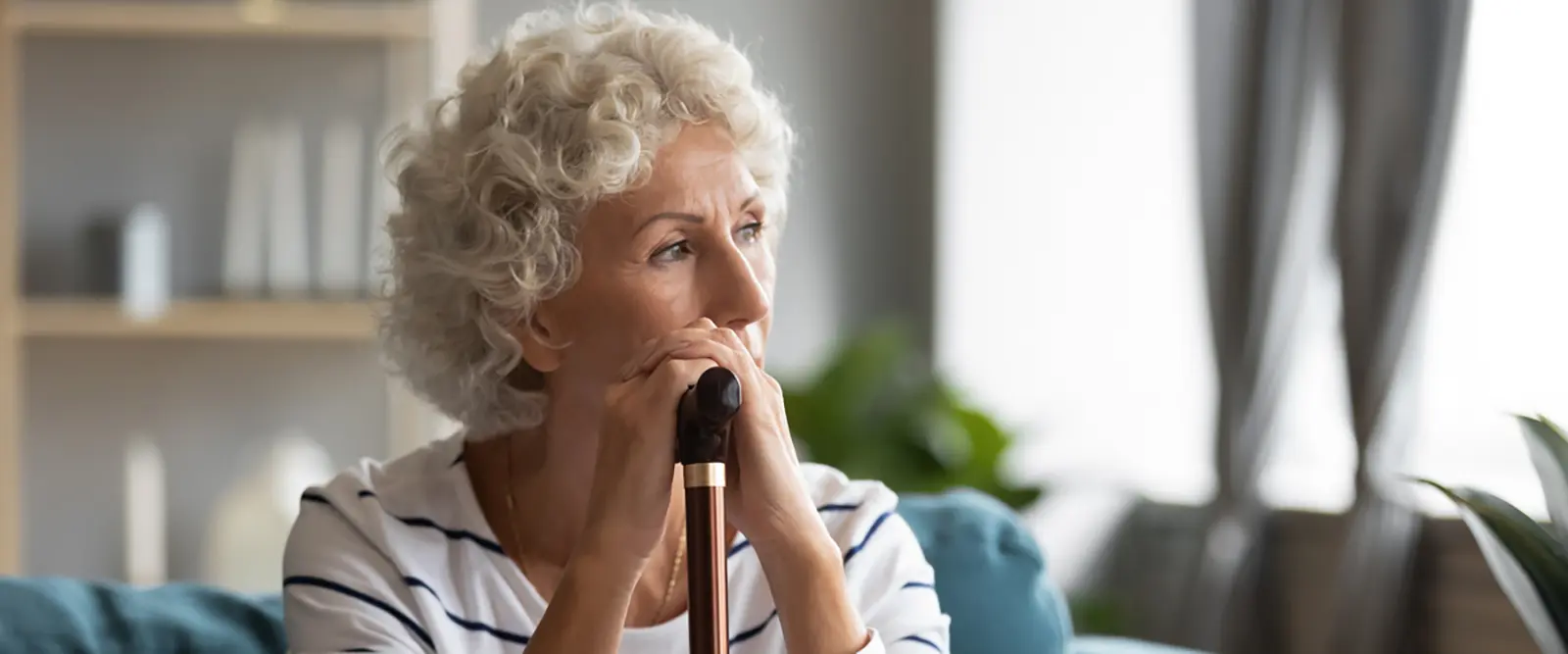 Woman with a cane looks off into the distance
