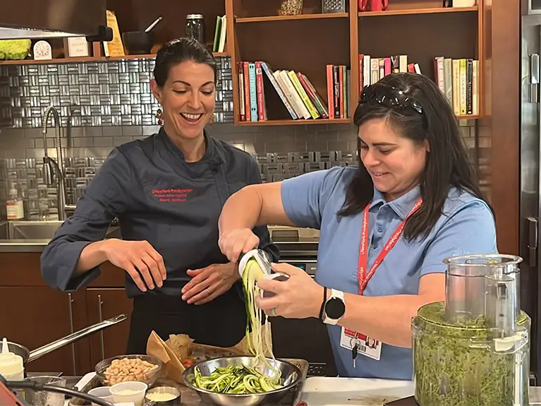 A woman making a salad in the kitchen.