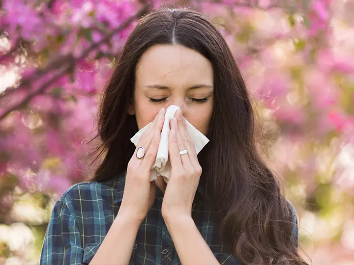 Woman clearing her nose because of spring allergies